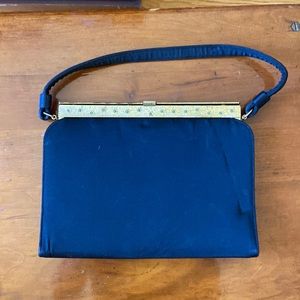 Vintage black satin like purse with gold closure with floral design.